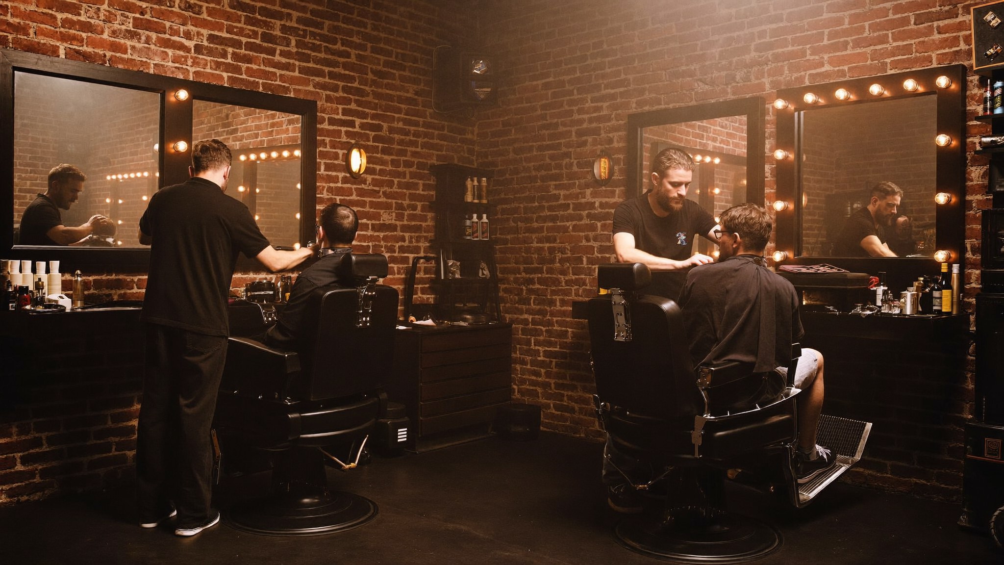 Interior de The Lords Barbería & Spa: barberos trabajando entre muros de ladrillo